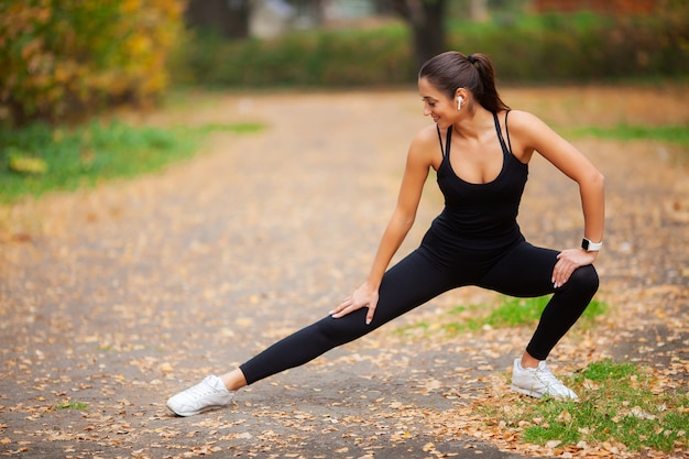 Fitness, Piękna młoda kobieta robi ćwiczenia w parku