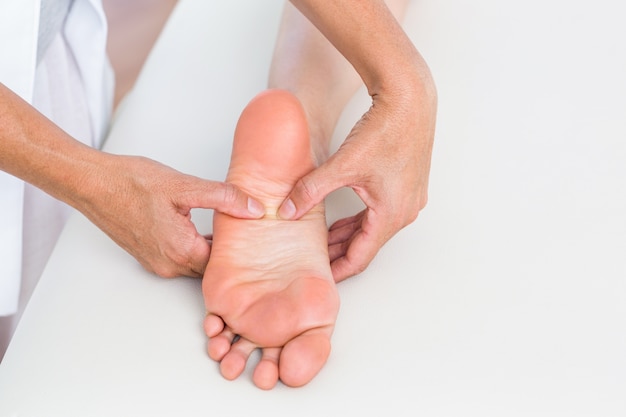 Zdjęcie fizjoterapeuta masuje stopę swoich pacjentów