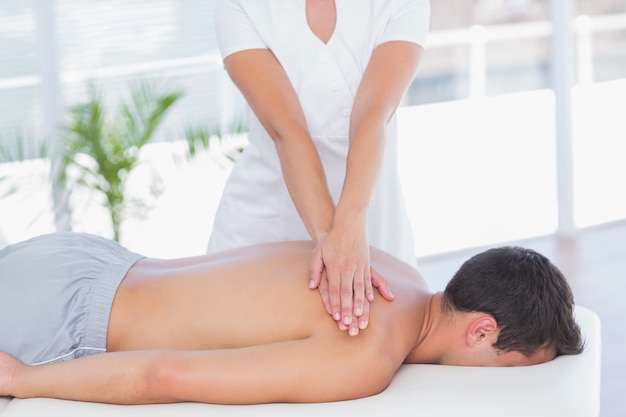 Fizjoterapeuta robi masaż ramion pacjentowi