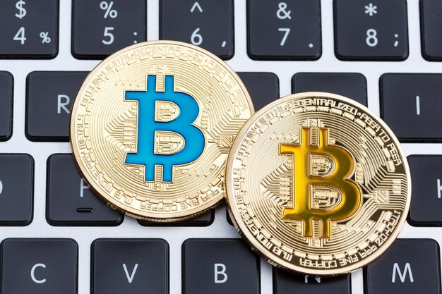 Fizyczne złote monety bitcoin cyfrowej waluty na czarnym komputerze