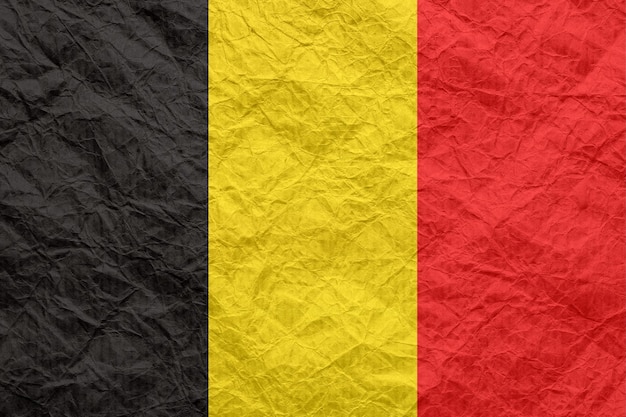 Flaga Belgii na starym zmiętym papierze rzemieślniczym Teksturowane tło tapety do projektowania