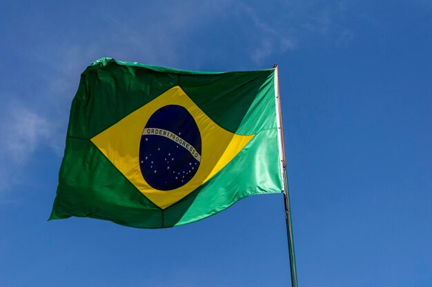 Flaga Brazylii powiewa na błękitnym niebie