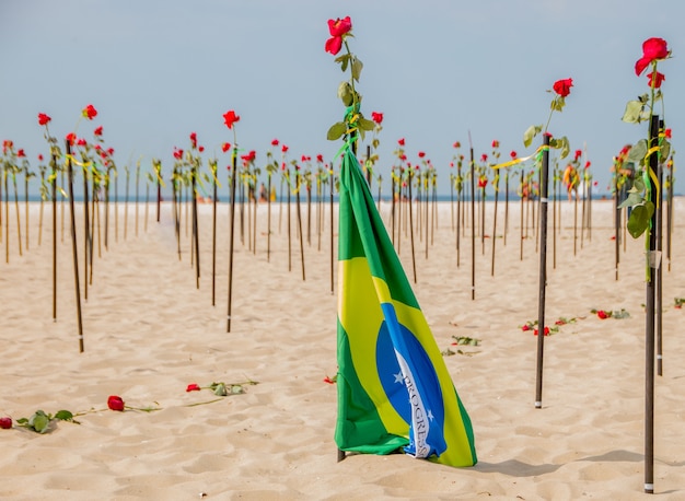 Zdjęcie flaga brazylii z różami w tle na plaży copacabana w rio de janeiro brazylia.