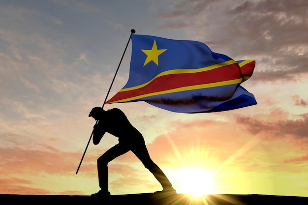 Flaga Demokratycznej Republiki Konga wbijana w ziemię przez męską sylwetkę Renderowanie 3D