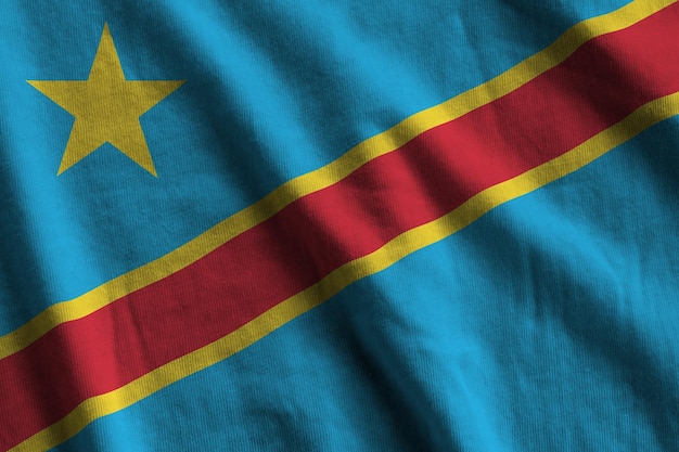 Flaga Demokratycznej Republiki Konga z dużymi fałdami macha z bliska pod światłem studyjnym w pomieszczeniu Oficjalne symbole i kolory na banerze