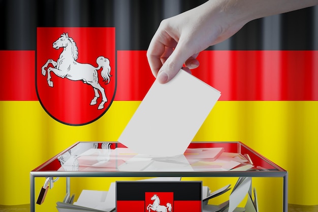 Zdjęcie flaga dolnej saksonii upuszcza kartę do głosowania w wyborach do skrzynki w koncepcji niemiec
