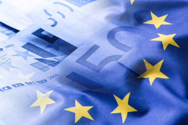 Zdjęcie flaga euro. pieniądze euro. waluta euro. kolorowe macha flagą unii europejskiej na tle pieniędzy euro.