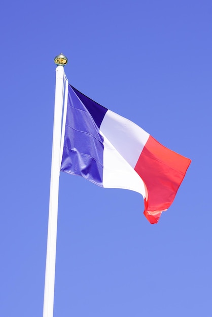 Flaga Francji francuska niebieska biała czerwona fala powiewa mata nad błękitnym niebem