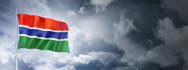 Flaga Gambii na zachmurzonym niebie