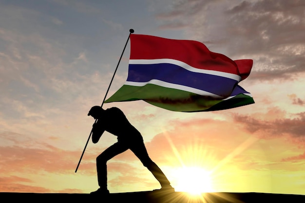 Flaga Gambii wbijana w ziemię przez męską sylwetkę Renderowanie 3D