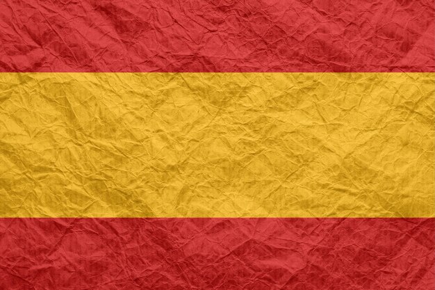 Flaga Hiszpanii na starym zmiętym papierze rzemieślniczym Teksturowane tło tapety do projektowania