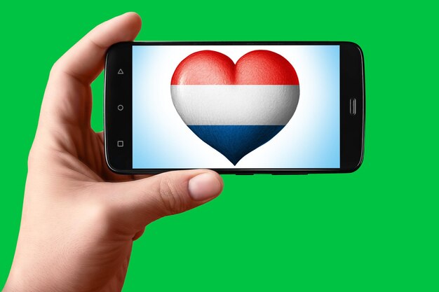 Flaga Holandii w kształcie serca na ekranie telefonu Smartfon w dłoni pokazuje flagowe serce na tle chroma key