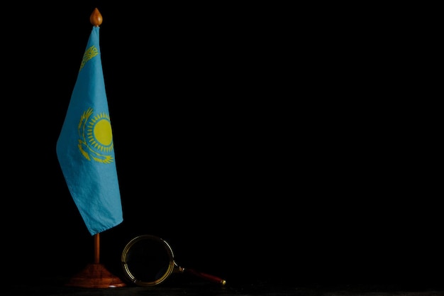 Flaga Kazachstanu i szkło powiększające na czarnym tle. Koncepcja, pod szczególną uwagą.