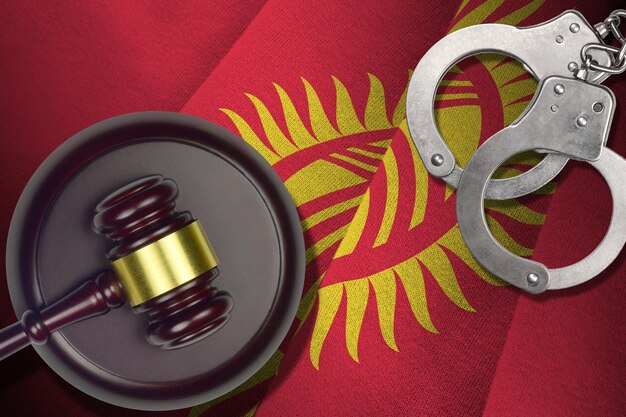 Flaga kirgistanu z młotkiem sędziego i kajdankami w ciemnym pokoju Koncepcja kryminalnego i karnego tła dla tematów osądu