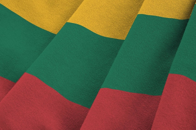 Flaga Litwy z dużymi fałdami macha z bliska pod światłem studyjnym w pomieszczeniu Oficjalne symbole i kolory na banerze