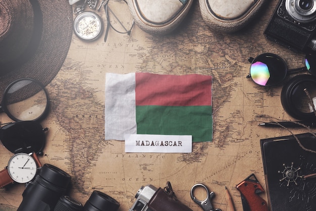 Flaga Madagaskaru między akcesoriami podróżnika na starej mapie vintage. Strzał z góry