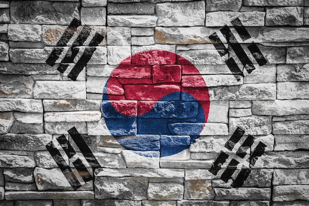 Flaga narodowa Korei Południowej na tle kamiennego muru