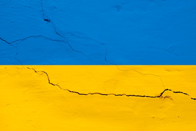 Flaga narodowa Ukrainy na starym murze w tle Żółtoniebieska flaga Ukrainy na popękanej ścianie Narodowa żółtoniebieska flaga Ukrainy