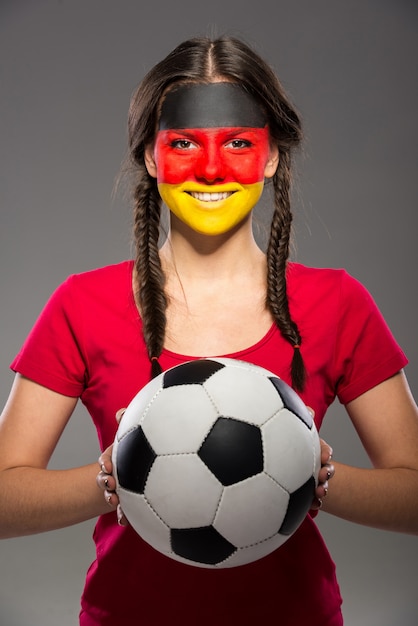Flaga Niemiec namalowana na twarzy młodej kobiety.