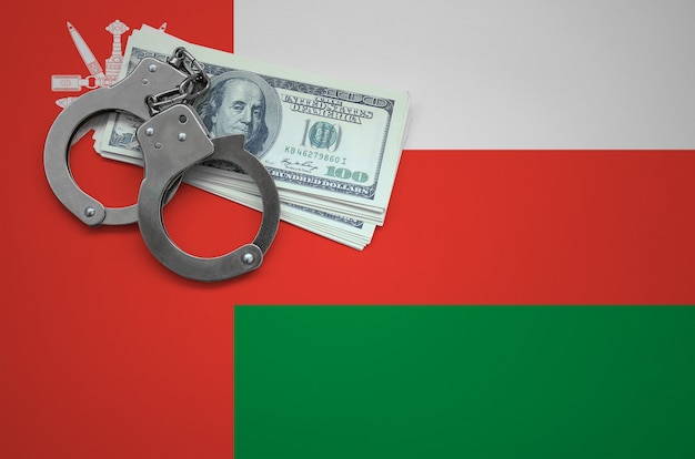 Zdjęcie flaga omanu z kajdankami i pakiet dolarów. pojęcie łamania prawa i zbrodni złodziei