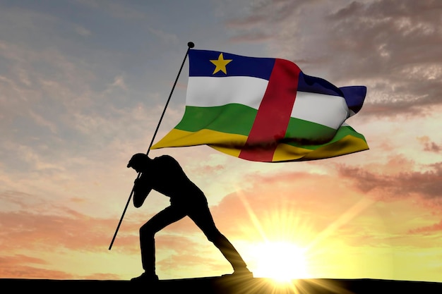 Flaga Republiki Środkowoafrykańskiej wbijana w ziemię przez męską sylwetkę Renderowanie 3D
