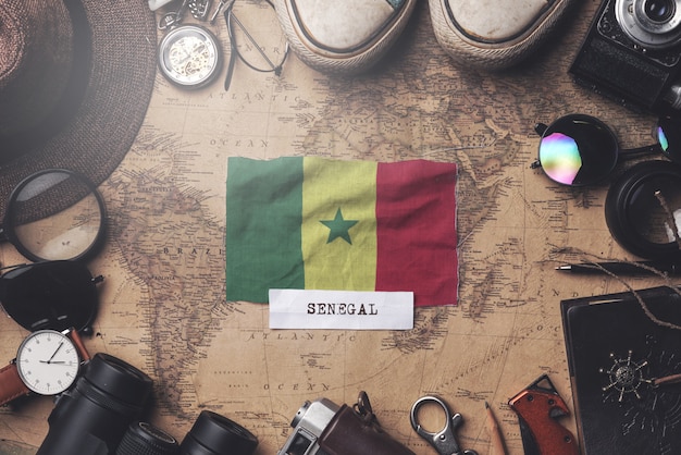 Flaga Senegalu Między akcesoriami podróżnika na starej mapie vintage. Strzał z góry