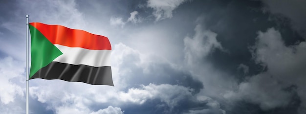 Flaga Sudanu na zachmurzonym niebie