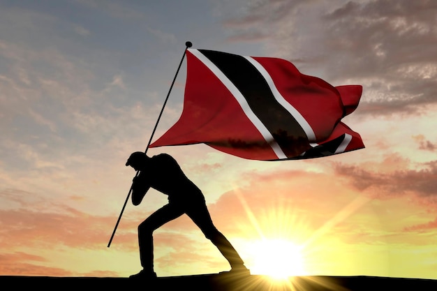 Flaga Trynidadu i Tobego wbijana w ziemię przez męską sylwetkę Renderowanie 3D