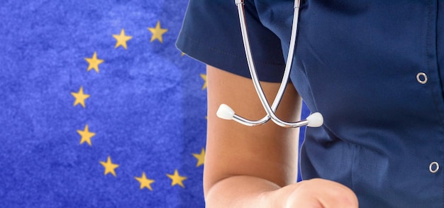 Zdjęcie flaga unii europejskiej lekarka ze stetoskopem, krajowy system opieki zdrowotnej