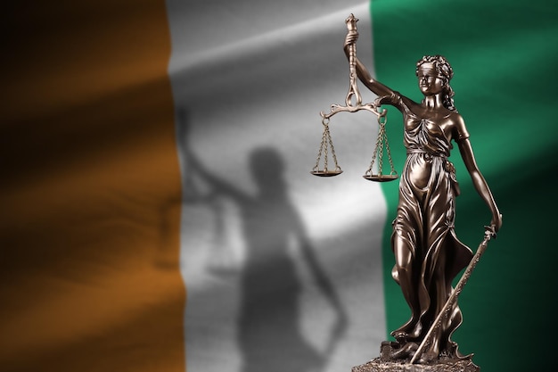 Flaga Wybrzeża Kości Słoniowej z posągiem sprawiedliwości i wagi sądowej w ciemnym pokoju Pojęcie wyroku i kary