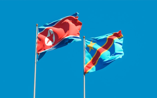 Flagi Korei Północnej i DR Konga na błękitnym niebie. Grafika 3D