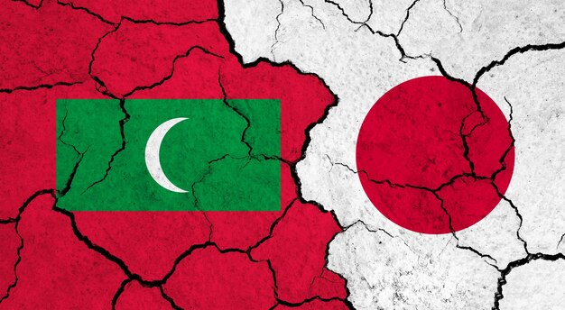 Flagi Malediwów i Japonii na pękniętej koncepcji relacji politycznych na powierzchni