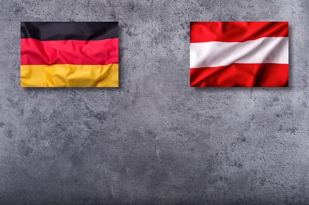 Flagi Niemiec i Austrii na betonowym tle.