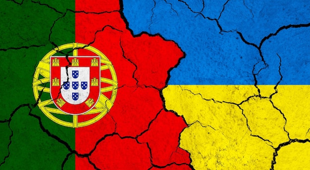 Zdjęcie flagi portugalii i ukrainy na pękniętej koncepcji relacji politycznych na powierzchni