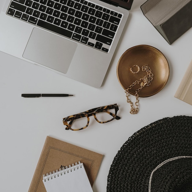 Flatlay laptop komputer notebook okulary biżuteria akcesoria mody damskiej Widok z góry minimalistyczna estetyczna koncepcja biznesowa pracy