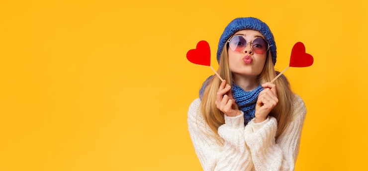 Zdjęcie flirtująca kobieta w zimowym kapeluszu trzymająca kartki walentynkowe