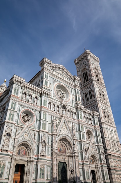 Florencja, Włochy - 24 czerwca 2018: Panoramiczny widok na Cattedrale di Santa Maria del Fiore (Katedra Matki Bożej Kwiatowej) i Campanile Giotta. Ludzie chodzą po placu w letni dzień