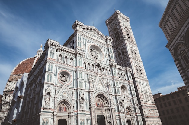 Florencja, Włochy - 24 czerwca 2018: Panoramiczny widok na Cattedrale di Santa Maria del Fiore (Katedra Matki Bożej Kwiatowej) i Campanile Giotta. Ludzie chodzą po placu w letni dzień