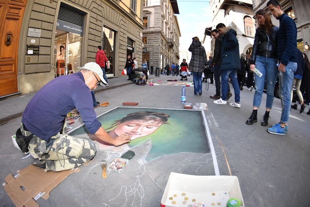 FLORENCJA, WŁOCHY - 27 marca 2017 r. - artysta maluje chodniki na ulicach