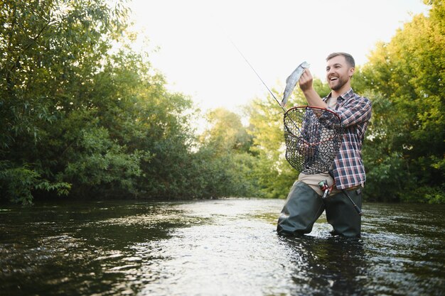 Flyfisher trzymający pstrąga z wody