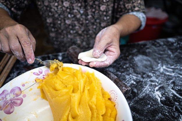 Focus kobieta ręcznie wyrabiająca ciasto na wietnamski pusty pączek Wykonane są z wody z mąki ryżowej