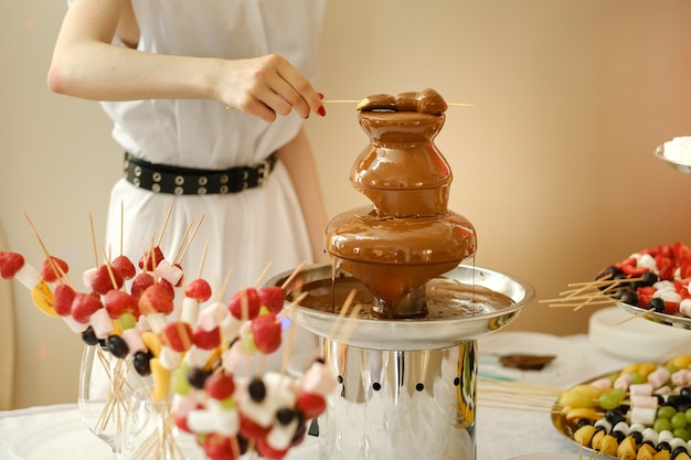 Fondue z czekoladową fontanną i słodyczami.Słodki motyw