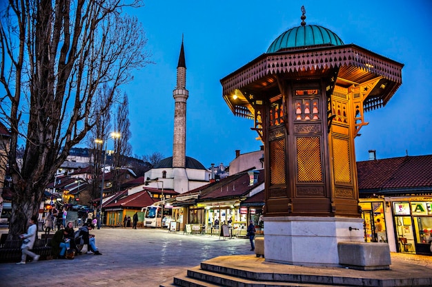 Fontanna Sebilj na Pigeon Square, dzielnica Bascarsija wieczorem w światłach, Sarajewo, Bośnia i Hercegowina