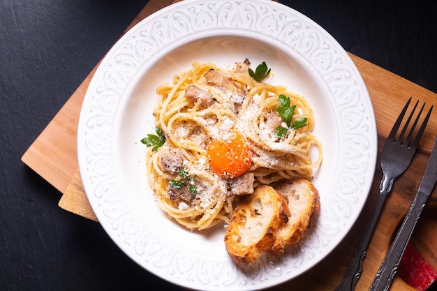 Zdjęcie food concept domowe klasyczne spaghetti carbonara na drewnianej desce z miejscem na kopię