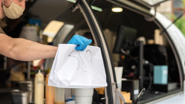 Food truck, kucharz przekazuje gotowe zamówienie