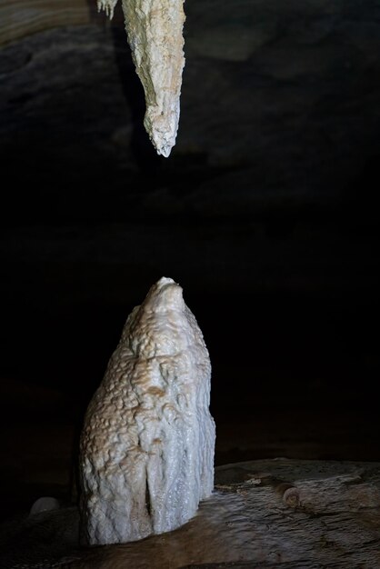 Formacja stalaktytów i stalagmitów w ciemnej jaskini