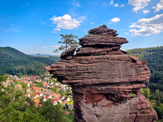 Formacja z piaskowca w lesie z wioską w tle