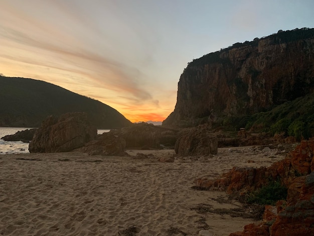 Zdjęcie formacje skalne na plaży na tle nieba podczas zachodu słońca