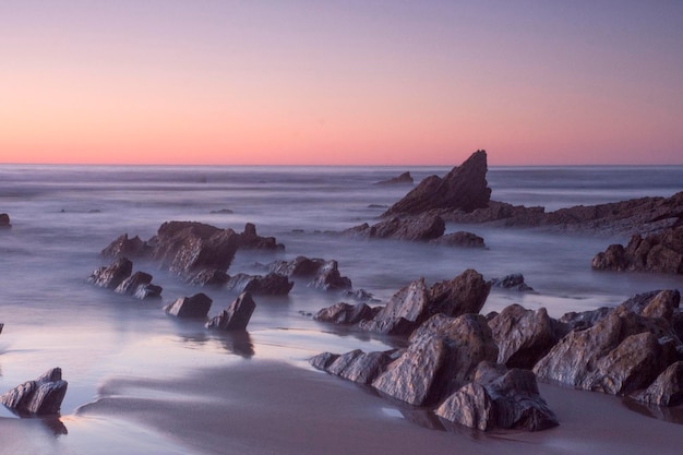 formacje skalne na plaży o zachodzie słońca