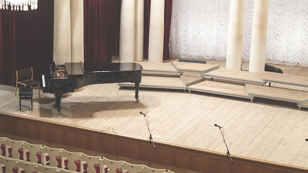 Fortepian na scenie i puste krzesła w audytorium sali koncertowej filharmonii